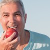 Man With Dentures Eating An Apple